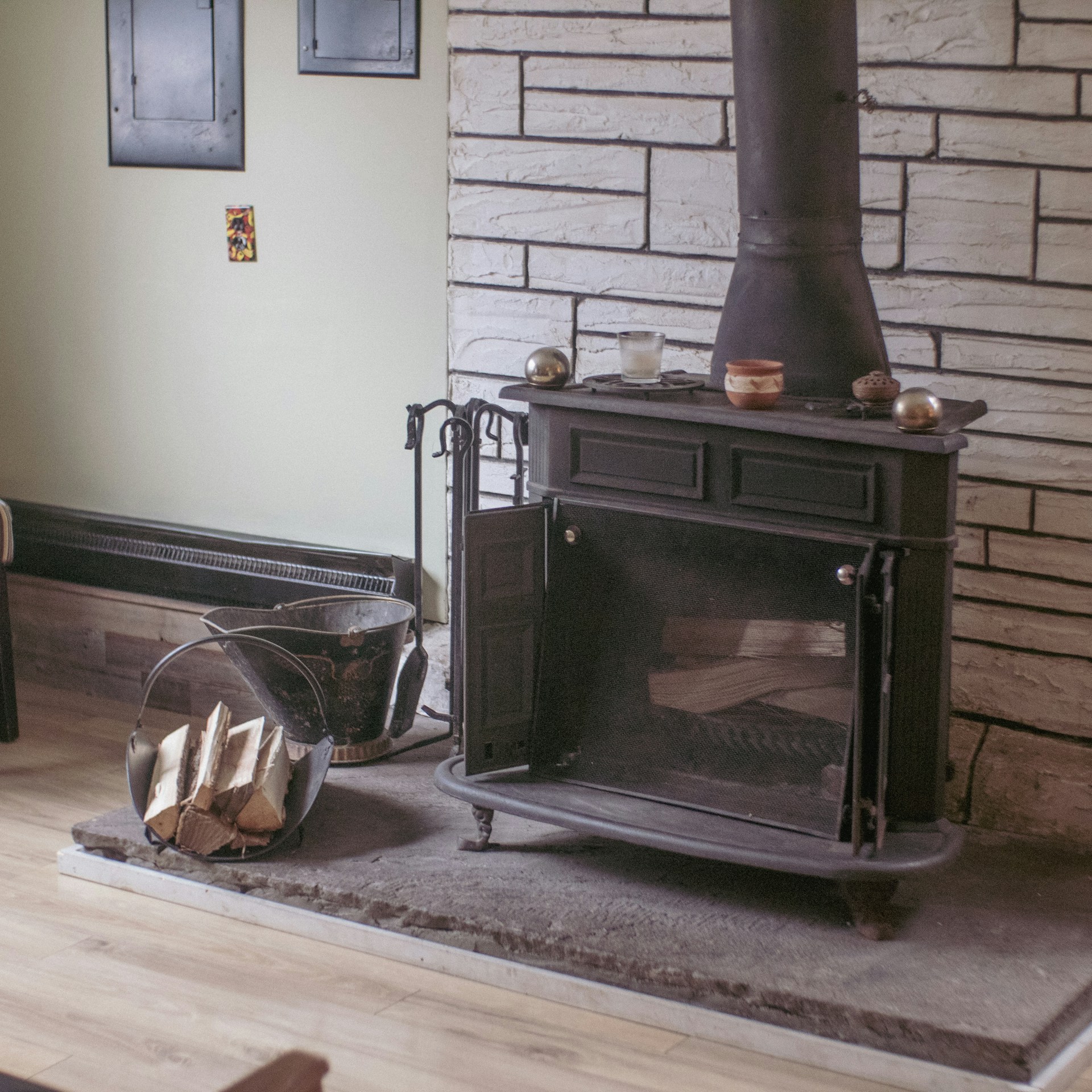 Dark slate hearth with wood burning stove and log basket in UK home